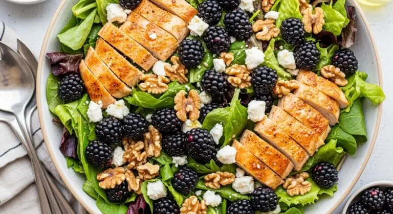 Stunning hero shot of a large salad bowl filled with the Blackberry Chicken Salad, showcasing mixed greens, grilled or shredded chicken, fresh blackberries, crumbled feta cheese, toasted walnuts, and a light vinaigrette dressing. Bright, natural light.