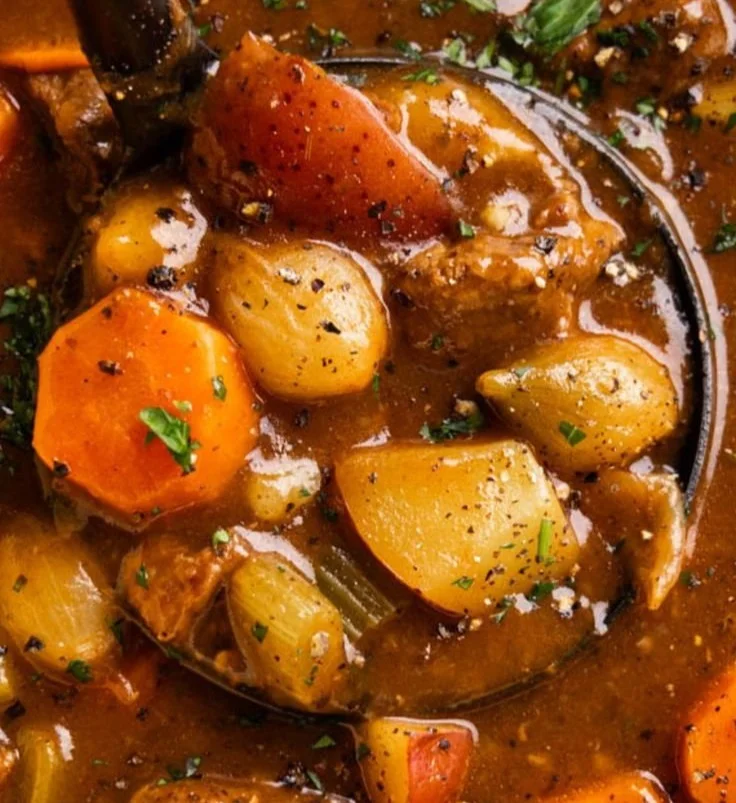 Hearty beef stew served in a rustic bowl with fresh herbs