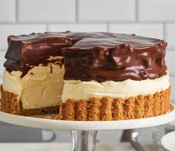 Slice of Boston Cream Pie with chocolate ganache and custard filling on a plate