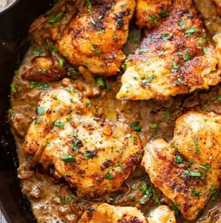 Creamy mustard chicken served on a plate with herbs and vegetables