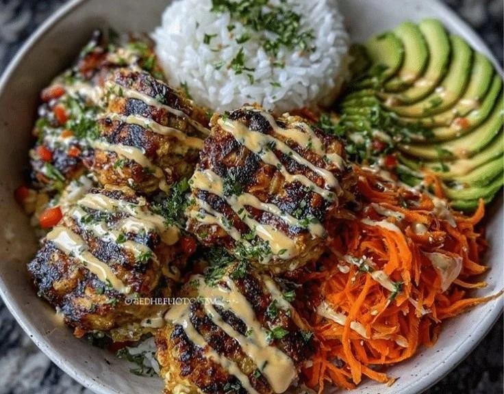Healthy Bang Bang Chicken Bowl topped with fresh vegetables and spicy sauce