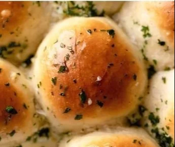 Freshly baked garlic bread rolls on a wooden table