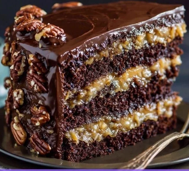 Delicious German Chocolate Cake with coconut-pecan frosting layered on a plate
