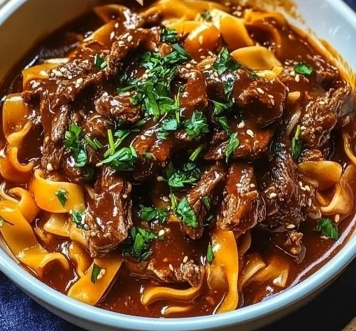 Delicious bowl of Korean beef noodles topped with fresh herbs and spices