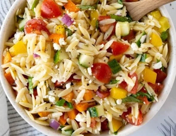 Colorful orzo salad with vegetables and herbs in a bowl