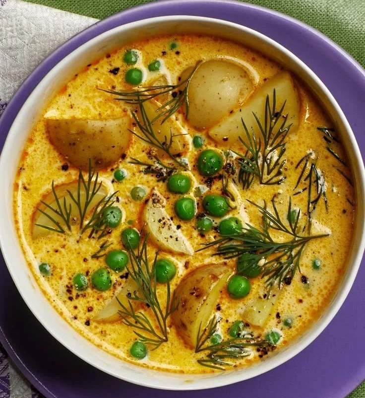 Bowl of creamy pea potato chowder garnished with fresh herbs