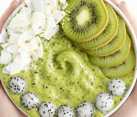 Pineapple kale smoothie bowl topped with fresh fruits and seeds
