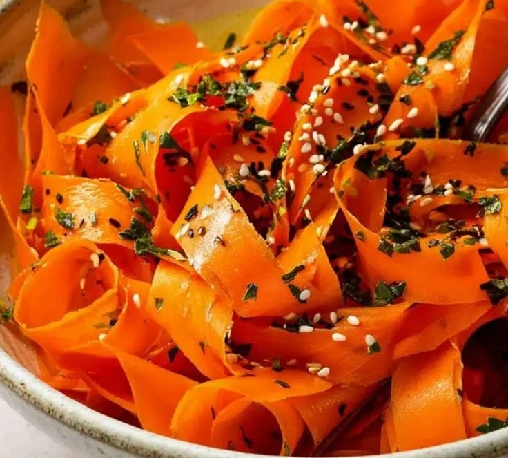 Colorful raw carrot salad with fresh ingredients and dressing