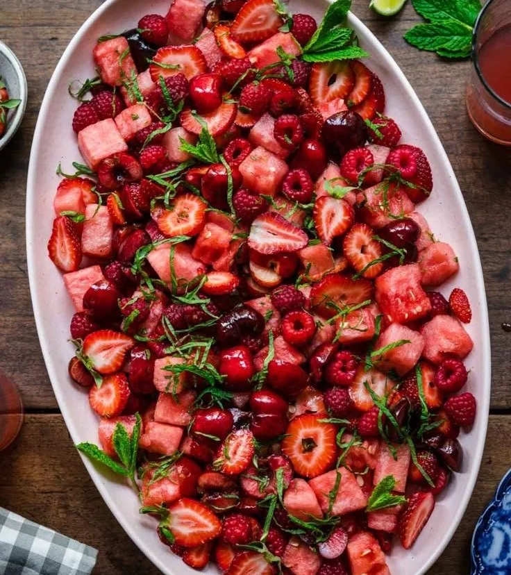 Vibrant watermelon fruit salad topped with lime mint dressing in a bowl.