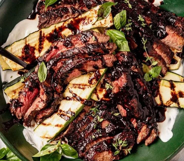 Balsamic flank steak with grilled zucchini and whipped feta on a plate