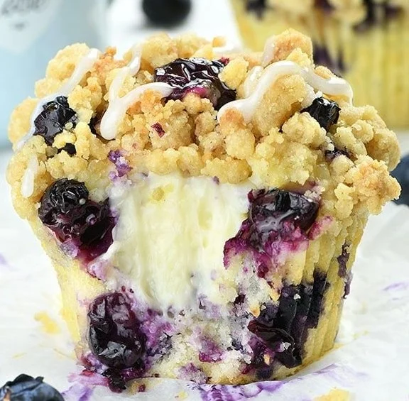 Blueberry muffins with cream cheese filling and streusel topping on a plate