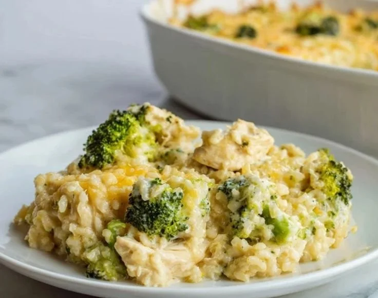 Cheesy Chicken Broccoli Rice Casserole in a baking dish with green garnish