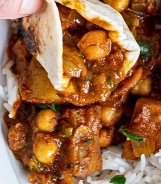 Chickpea potato curry with spices and herbs in a bowl