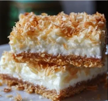 Delicious Coconut Cream Bars topped with shredded coconut and creamy frosting