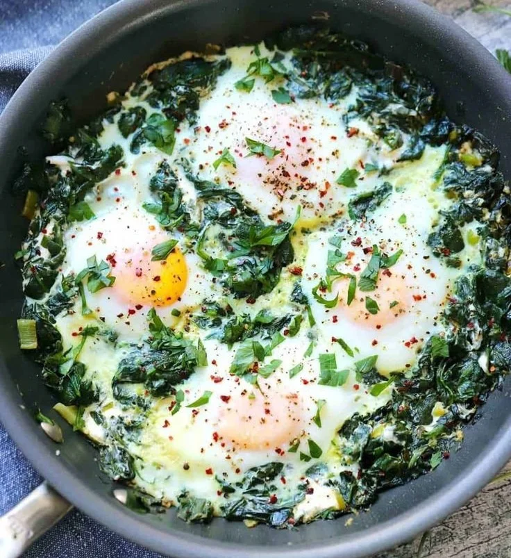 Creamy spinach and eggs dish served in a bowl for breakfast