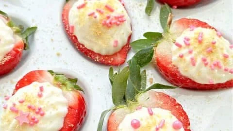 Plate of deviled strawberries filled with cream cheese and herbs