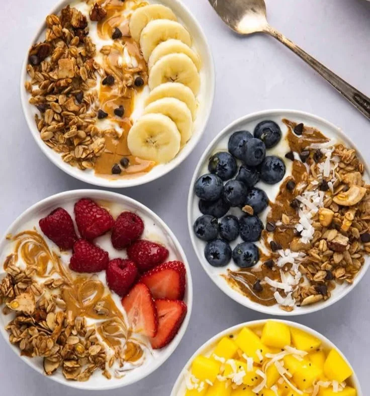 Four delicious yogurt granola bowls with fruit and toppings