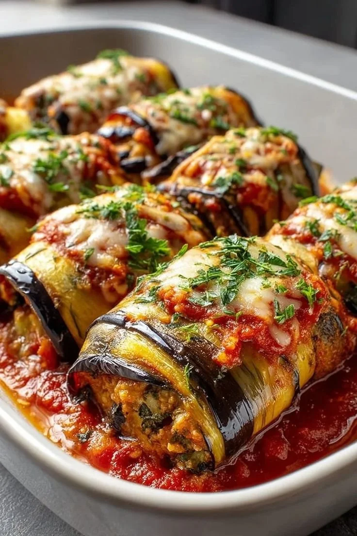 Delicious Eggplant Rollatini filled with cheese and herbs, garnished with marinara sauce.