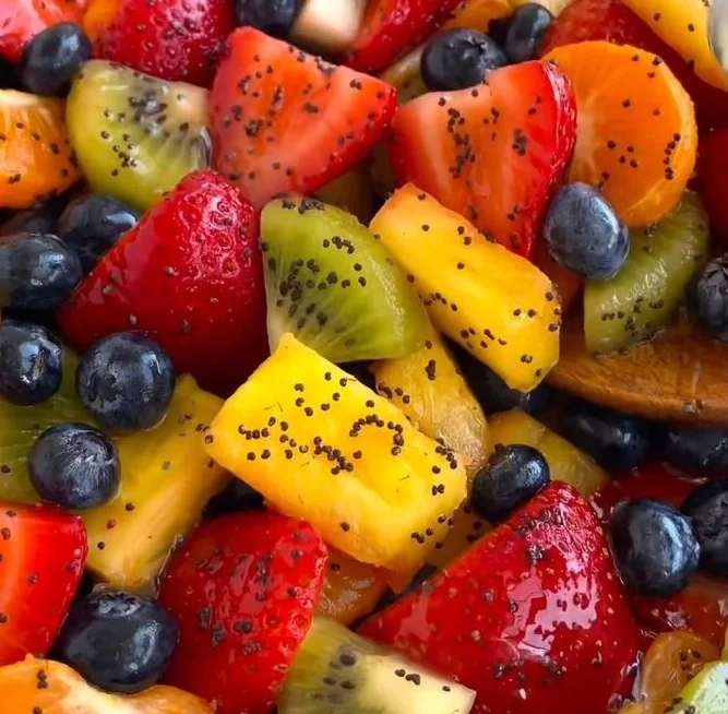 Fresh fruit salad with honey lime poppy seed dressing served in a bowl