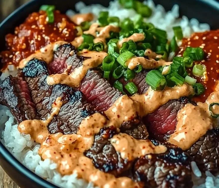Korean BBQ steak rice bowl with spicy cream sauce garnished with vegetables