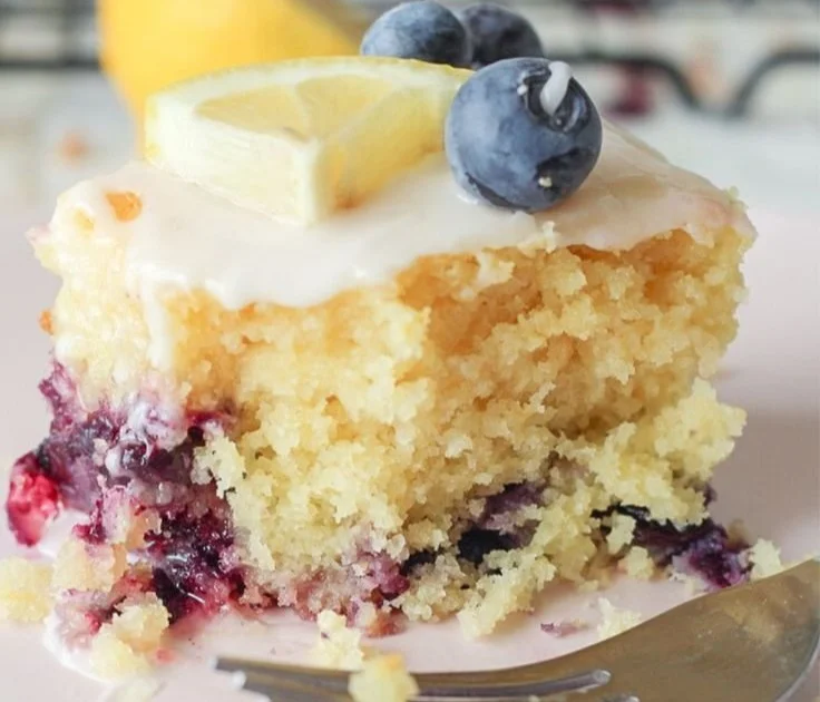 Delicious slice of Lemon Blueberry Sheet Cake topped with fresh blueberries.
