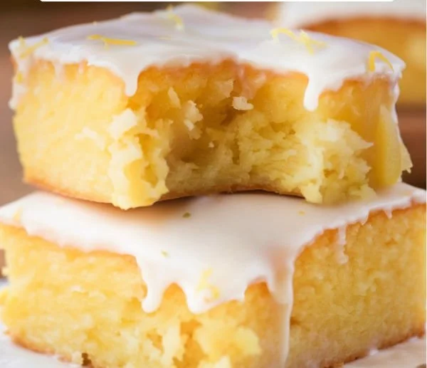 Delicious lemon brownies topped with powdered sugar on a plate
