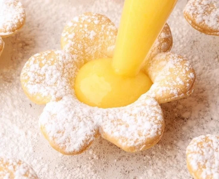 Fresh lemon curd tartlets garnished with lemon slices and mint leaves.