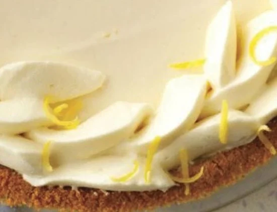 Slice of Limoncello Cream Pie topped with lemon zest and whipped cream