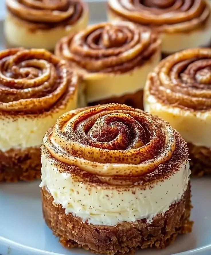 Mini cinnamon roll cheesecakes topped with icing and cinnamon swirl