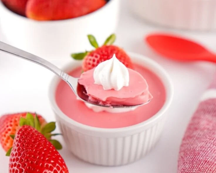 A colorful bowl of Protein Fluffy Jello topped with berries and whipped cream.