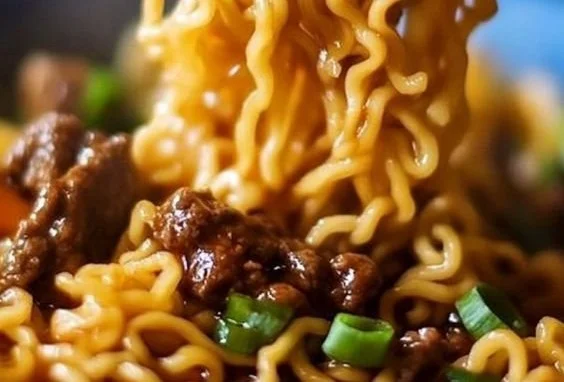 Bowl of slow cooker beef ramen noodles with vegetables and herbs