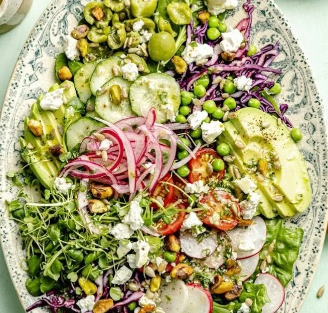 Spring Green Salad topped with Lemon Basil Vinaigrette in a bowl