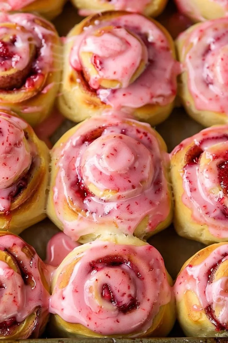 Freshly baked strawberry cinnamon rolls topped with glaze and fresh strawberries
