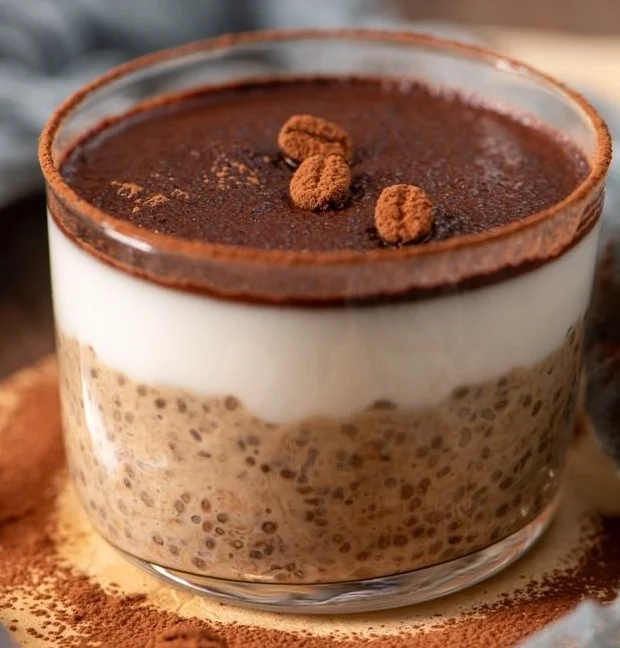 Tiramisu chia pudding topped with Greek yogurt and cocoa powder in a glass