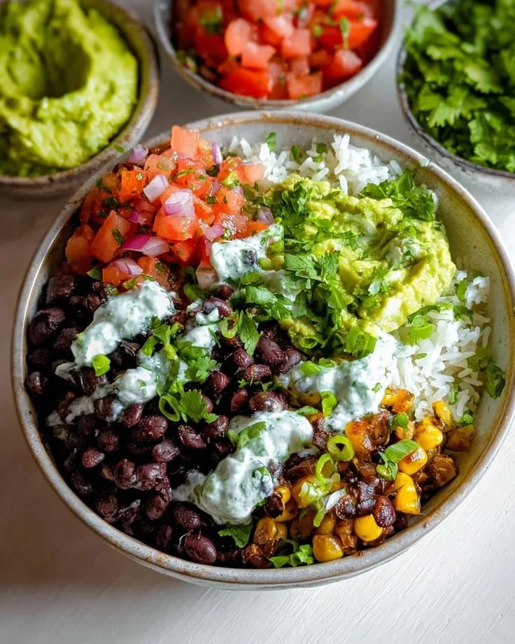 A colorful Vegan Burrito Bowl filled with rice, beans, vegetables, and avocado