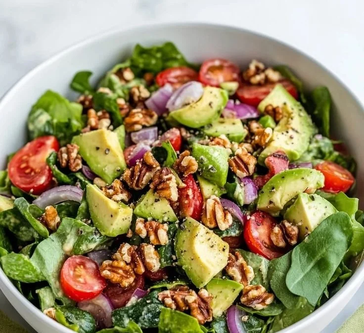 Vibrant spring salad with avocado, mixed greens, and colorful vegetables.