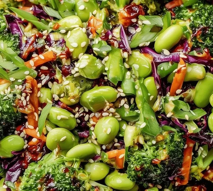 Fresh broccoli salad with colorful vegetables and dressing served in a bowl.