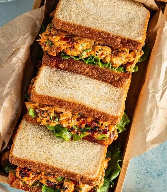 Chicken Salad Sandwich topped with Chili Crisp, showcasing fresh ingredients.