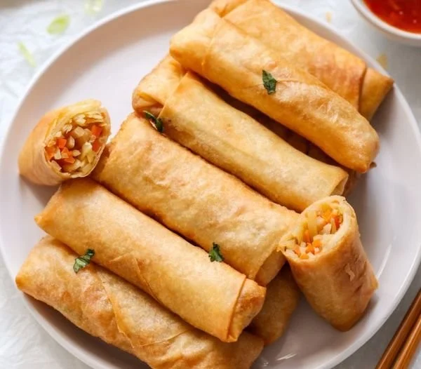 Plate of crispy Chinese vegetable spring rolls served with dipping sauce