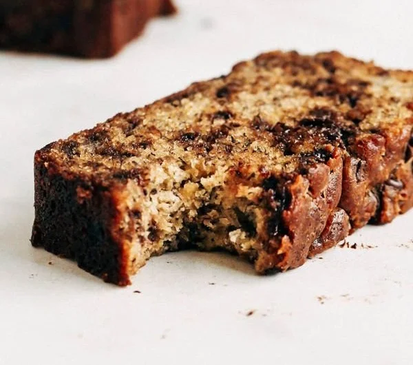Chocolate chip banana bread freshly baked and sliced on a wooden board