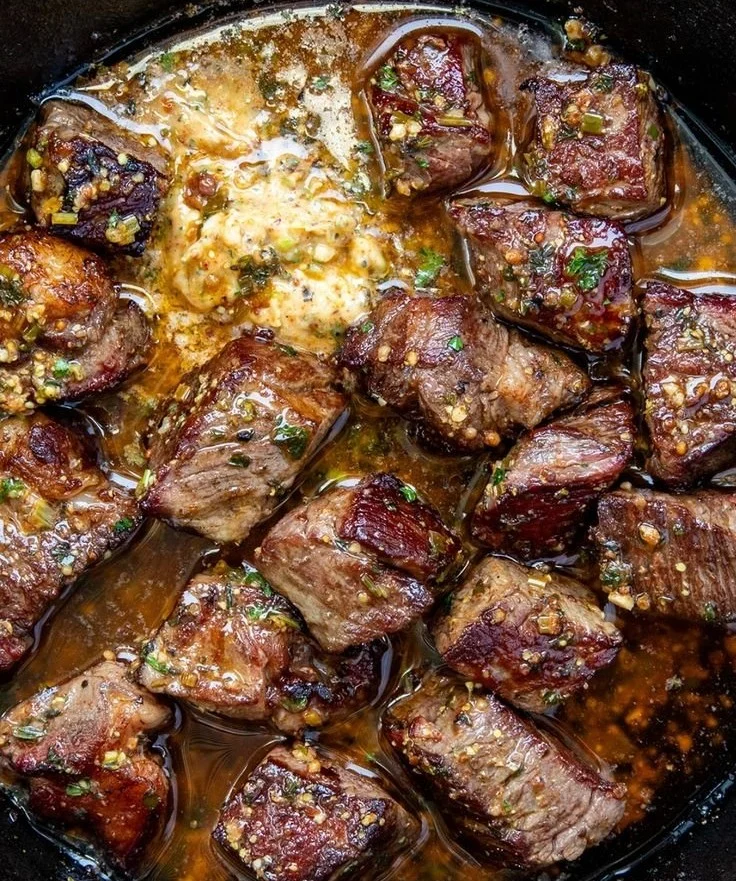 Plate of Cowboy Butter Steak Bites topped with fresh herbs and spices.