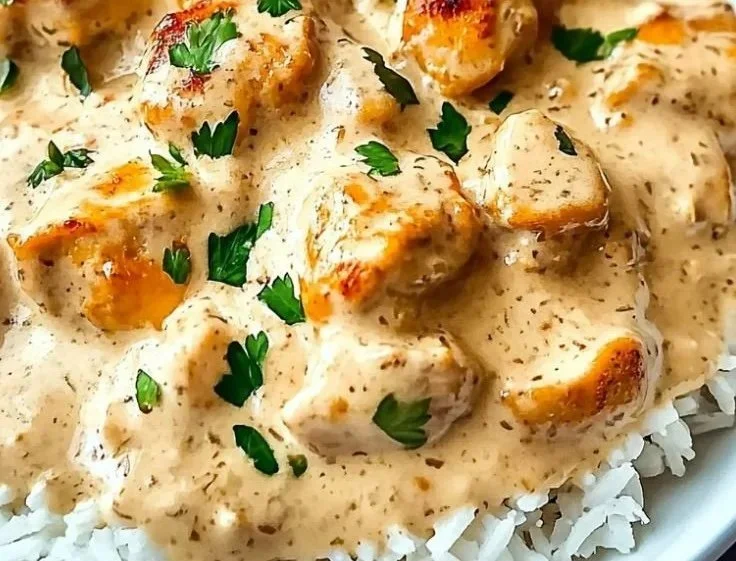 Creamy smothered chicken served with rice, a delicious comfort food dish
