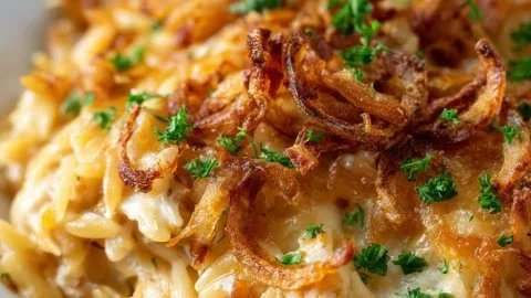 French Onion Chicken Orzo Casserole topped with melted cheese and herbs