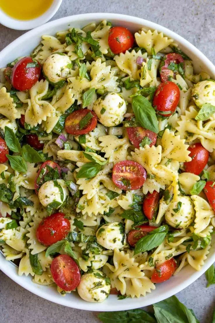 Colorful Italian bow tie pasta salad with fresh vegetables and dressing