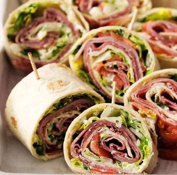A platter of colorful Italian Pinwheel Sandwiches filled with fresh ingredients.
