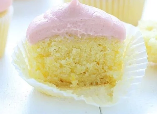Lemon cupcakes topped with strawberry buttercream frosting