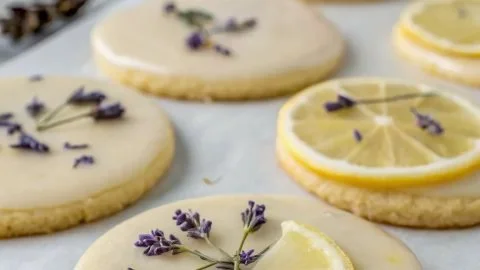 Delicious lemon lavender cookies on a serving plate with fresh lemons and lavender