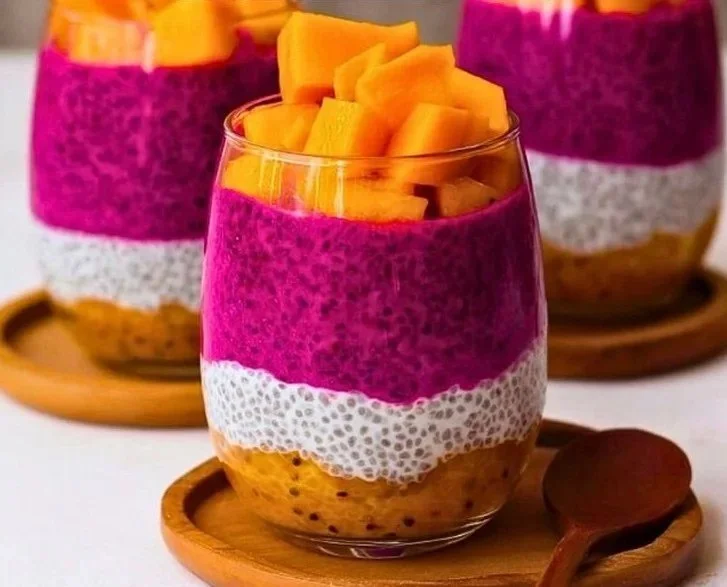 Mango and dragon fruit chia pudding topped with fresh fruit and nuts