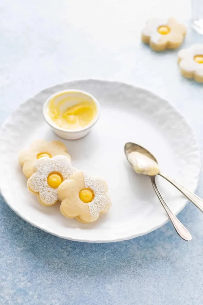 Meyer Lemon Curd Linzer Cookies with citrus glaze on a decorative plate