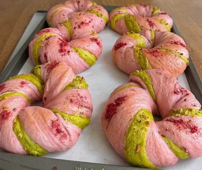Fresh Raspberry Pistachio Sourdough Bagels on a wooden surface